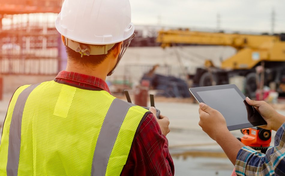 Zdjęcie przedstawia robotników z narzędziami na budowie